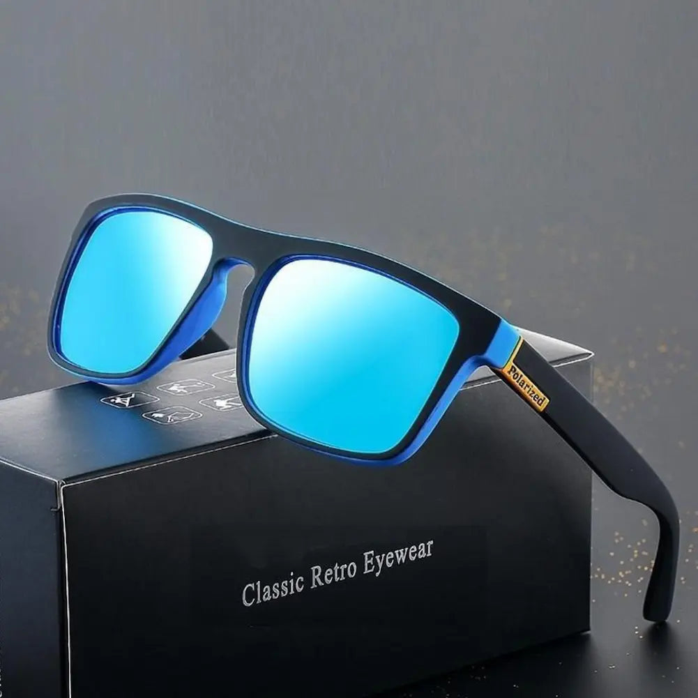 A imagem mostra um par de óculos de sol com lentes espelhadas azuis e armação preta, apoiado sobre uma caixa preta. Na haste dos óculos, há um detalhe dourado com a inscrição "Polarized". A caixa preta tem o texto "Classic Retro Eyewear" em branco. O fundo é cinza escuro com pequenos pontos dourados dispersos, criando um efeito elegante.